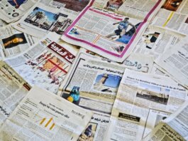 Close-up view of various newspapers laid out, showcasing diverse headlines and articles.