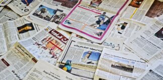 Close-up view of various newspapers laid out, showcasing diverse headlines and articles.
