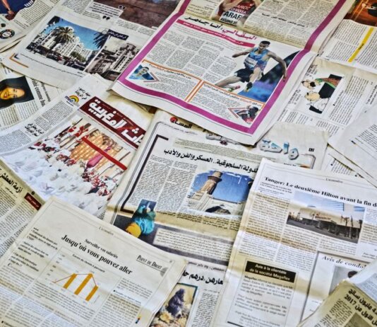 Close-up view of various newspapers laid out, showcasing diverse headlines and articles.