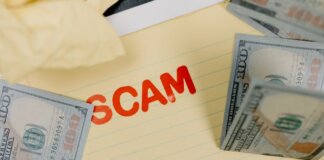 Conceptual image of financial scam with US dollars on yellow paper and word 'scam' visible.