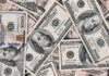 Путешествия важнее быта: исследование Booking.com о приоритетах туристов Detailed close-up of US dollar bills highlighting wealth and finance concepts.