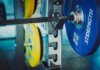 Detailed view of 20 kg weights on a barbell in a gym, emphasizing strength and fitness.