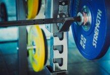 Detailed view of 20 kg weights on a barbell in a gym, emphasizing strength and fitness.