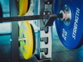 Detailed view of 20 kg weights on a barbell in a gym, emphasizing strength and fitness.