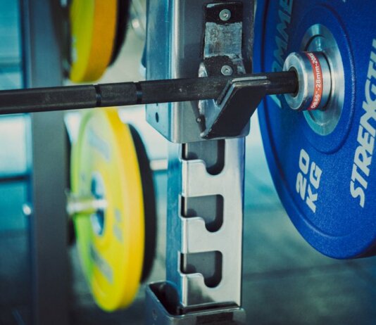 Detailed view of 20 kg weights on a barbell in a gym, emphasizing strength and fitness.