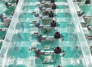 Detailed view of organized electronic circuit boards in a production setting.
