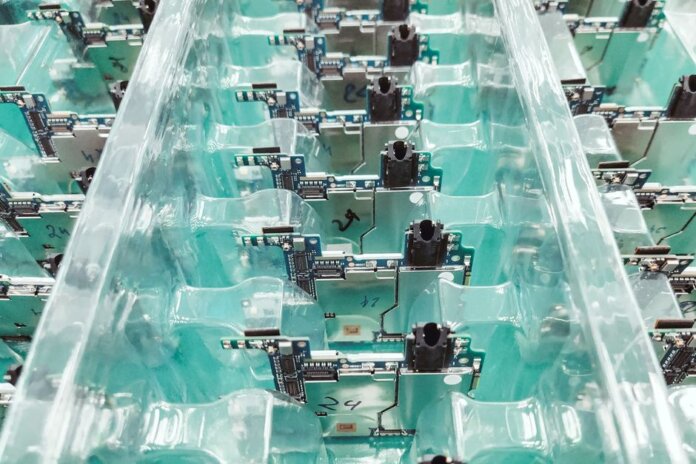 Detailed view of organized electronic circuit boards in a production setting. Detailed view of organized electronic circuit boards in a production setting.