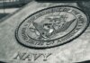 Detailed view of the United States Navy emblem on a monument in Washington D.C., showcasing naval heritage.