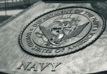 Detailed view of the United States Navy emblem on a monument in Washington D.C., showcasing naval heritage.
