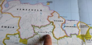 Discover Roraima, Brazil with a finger pointing on a detailed map.