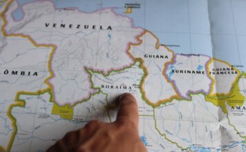 Discover Roraima, Brazil with a finger pointing on a detailed map.