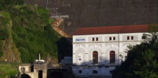 В Дельте построят энергоцентр для больницы за $24,4 млн Eguzon hydroelectric plant by a river during sunset, surrounded by lush greenery.