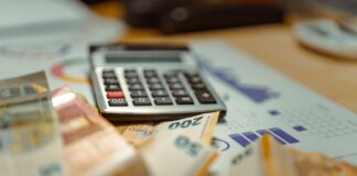 Euro banknotes and calculator on financial documents, focusing on business budget planning.