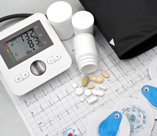 Health Canada одобрило 15 новых препаратов и 481 медицинское устройство Flat lay of blood pressure monitor, pills, and ECG printout for heart health theme.