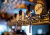 Focused image of a shiny beer tap in a stylish bar with a blurred background.