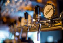 Focused image of a shiny beer tap in a stylish bar with a blurred background.