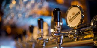 Focused image of a shiny beer tap in a stylish bar with a blurred background.