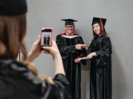 Graduates celebrating achievement in cap and gown, capturing memories.