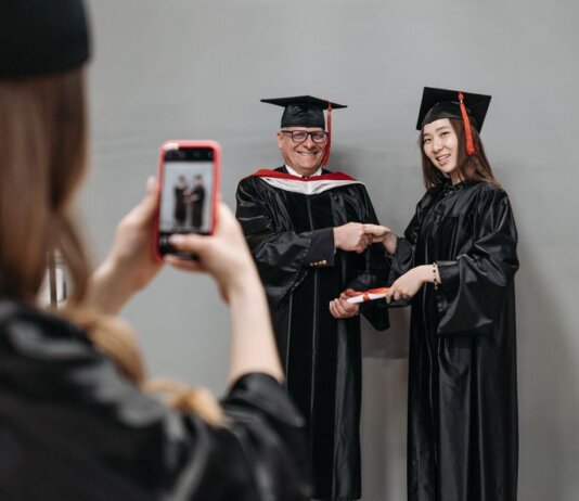Graduates celebrating achievement in cap and gown, capturing memories.