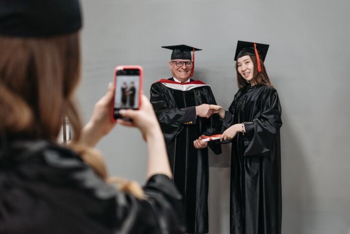 Graduates celebrating achievement in cap and gown, capturing memories. Graduates celebrating achievement in cap and gown, capturing memories.