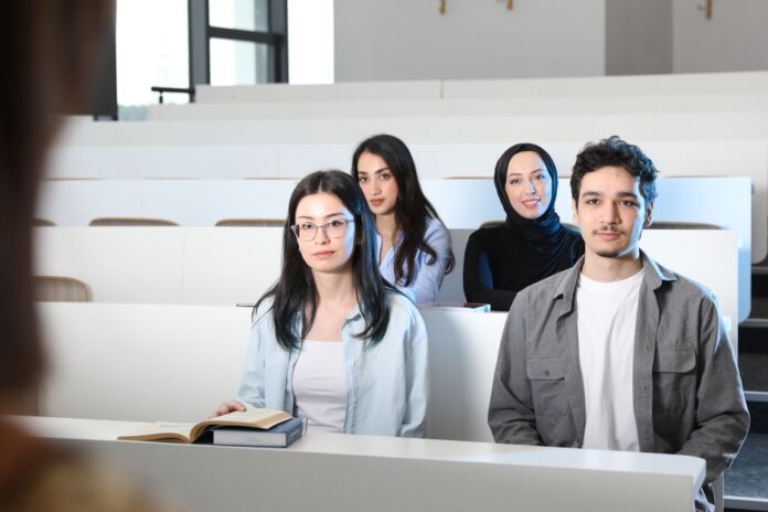 Group of diverse university students attending a class session in a modern lecture hall. Group of diverse university students attending a class session in a modern lecture hall.