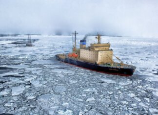 Icebreaker ship cutting through vast frozen ocean, showcasing winter exploration.