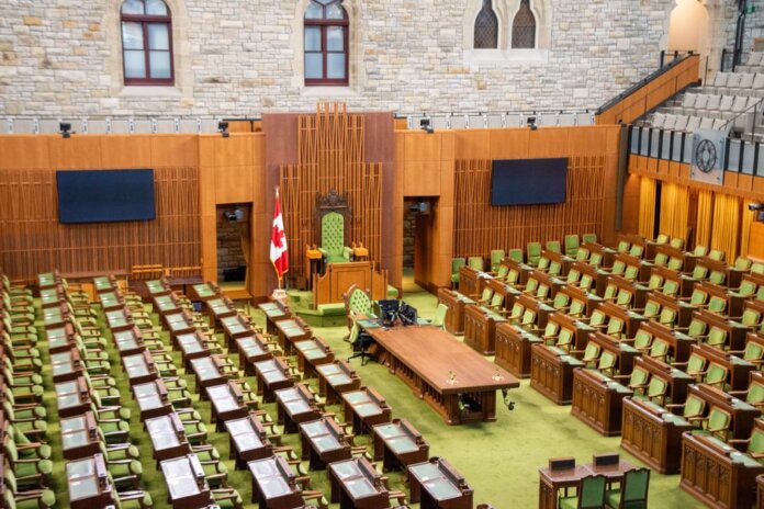 Interior view of the Canadian House of Commons with green seating and wooden decor. Interior view of the Canadian House of Commons with green seating and wooden decor.