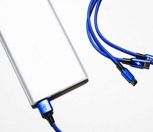 Minimalist image of a power bank with blue USB charging cables on a white background.