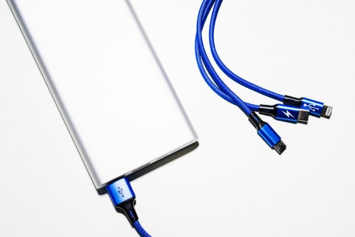 Minimalist image of a power bank with blue USB charging cables on a white background. Minimalist image of a power bank with blue USB charging cables on a white background.