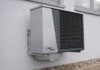 Выпускник UBC создал в Келоуне компанию по производству тепловых насосов Outdoor air conditioning unit mounted on a residential building exterior.