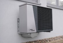 Выпускник UBC создал в Келоуне компанию по производству тепловых насосов Outdoor air conditioning unit mounted on a residential building exterior.
