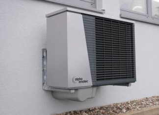 Outdoor air conditioning unit mounted on a residential building exterior.