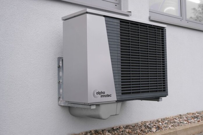 Outdoor air conditioning unit mounted on a residential building exterior. Outdoor air conditioning unit mounted on a residential building exterior.