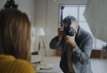 Photographer capturing a portrait in a well-lit indoor studio setting.