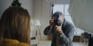 Photographer capturing a portrait in a well-lit indoor studio setting.