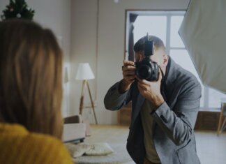 Photographer capturing a portrait in a well-lit indoor studio setting.