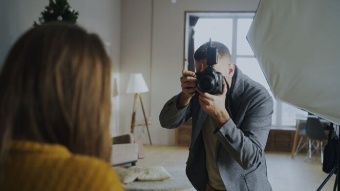 Photographer capturing a portrait in a well-lit indoor studio setting.