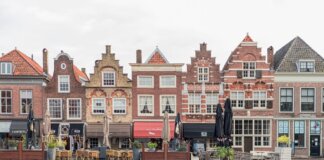 Picturesque European street featuring traditional Dutch gabled buildings and open air cafes.