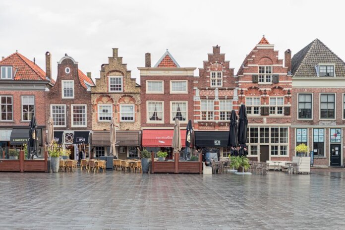 Picturesque European street featuring traditional Dutch gabled buildings and open air cafes. Picturesque European street featuring traditional Dutch gabled buildings and open air cafes.