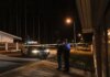 Женщина ранена ножом при ночном вторжении в дом в Лондоне, Онтарио Police officers at a nighttime crime scene with a police car and caution tape under streetlights.