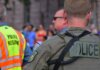 Лондон (Онтарио) отмечает 30-летие партнёрства полиции с центром ДТП Police officers maintaining security at a public event with a crowd in the background.