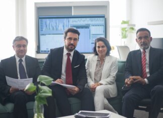 Министр финансов обсудил с провинциями ответ Канады на тарифы США Professional team in corporate attire ready for a meeting, engaged in discussion.