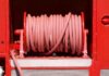 Red fire hose coiled neatly on a fire truck in Bow of Fife, Scotland.