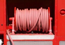 Red fire hose coiled neatly on a fire truck in Bow of Fife, Scotland.