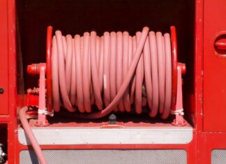 Red fire hose coiled neatly on a fire truck in Bow of Fife, Scotland.