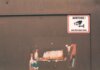 Rusty industrial door with a German surveillance warning sign