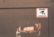 Rusty industrial door with a German surveillance warning sign