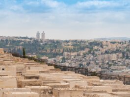Scenic view of Jerusalem, Israel, featuring a historic cemetery and urban landscape under a blue sky.