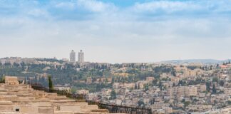 Израиль закрывает расследование обстрела конвоя World Central Kitchen Scenic view of Jerusalem, Israel, featuring a historic cemetery and urban landscape under a blue sky.