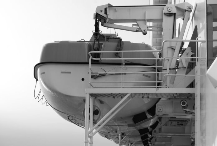 Side view of a lifeboat secured on a ship deck in black and white. Side view of a lifeboat secured on a ship deck in black and white.